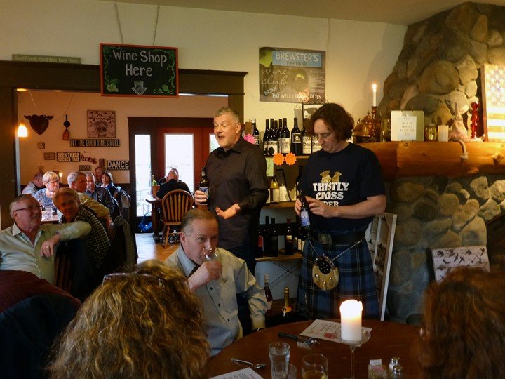 Bruce Wright, l., and Peter Stuart explain the ins and outs of cider to an appreciative crowd at Brewster’s on March 17.    Photo by Louise Mugar